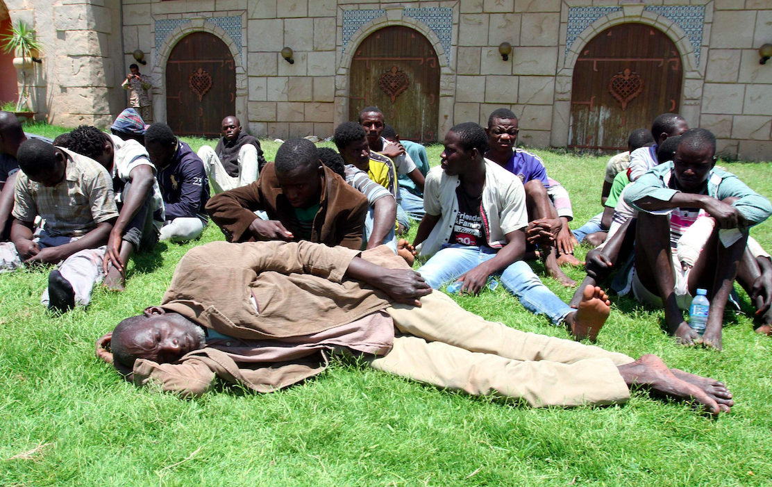 African migrants look on at a detention center, in Tripoli, Libya, 14 June 2014. According to media reports, Libyan authorities arrested some 95 African migrants at the Mediterranean Bouri Oil field, some 130 Km off Tripoli shores while trying to reach Europe on fishing boats. EPA/SABRI ELMHEDWI