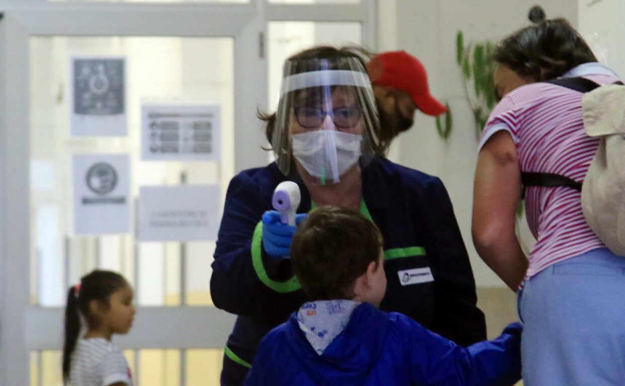 Alunni di una scuola materna vengono controllati prima dell'entrata a scuola