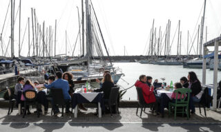 Sul litorale romano piena attività per ristoranti a pranzo È piena attività oggi, in vista del pranzo, per ristoranti e locali fronte mare sul litorale romano, da Fiumicino a Fregene ed in altre località del "mare di Roma". Il trend delle prenotazioni, considerata la "zona gialla", viene definito buono, richiamati anche dalla temperatura oltre i 15 gradi seppur disturbata da un vento fastidioso. Segnalato, in mattinata, dalla polizia locale di Fiumicino un graduale aumento del flusso di auto dalla Capitale e dintorni. Alternativa alla cucina sono le passeggiate, ad Ostia e Fiumicino, lungo i moli dei porti, sul pontile e sui lungomare. Ad approfittarne soprattutto famiglie con bambini e runners, Ostia, 6 Febbraio 2020. ANSA/EMANUELE VALERI