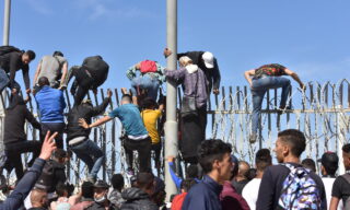 Migrants cross from Morocco into Ceuta, Spain epa09210801 Migrants climb the fence in the northern town of Fnideq in an attempt to cross the border from Morocco to the Spanish enclave of Ceuta, in North Africa 18 May 2021. In little over 24 hours a total of almost 8,000 people entered into the Spanish city of Ceuta, located in the North African coast, by sea side and hundreds of migrants continue to attempt doing so. The Spanish authorities have deployed the army to patrol on the border separating Ceuta in the Spanish side from the Moroccan side, in a bid to control this latest surge of entry attempts. EPA/JALAL MORCHIDI