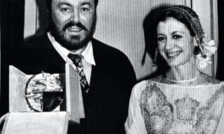 PAVAROTTI: IL TENORE ITALIANO FAMOSO NEL MONDO / SPECIALE 19830311-MILANO-Patrocinato da Nicola Trussardi, al termine della sfilata alla Scala, premiato il tenore Luciano Pavarotti con il premio 'Immagine Italia'. Nella foto: Luciano Pavarotti mostra il premio ricevuto al fianco di Carla Fracci. ANSA ARCHIVIO/A 11436