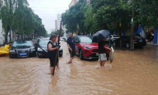 Heavy floods in Central China Zhengzhou epa09356101 People walk on a flooded road amid heavy rain in Zhengzhou, Henan province, China, 21 July 2021. Heavy floods in Central China killed 12 in Zhengzhou city due to the rainfall yesterday, 20 July 2021, according to official Chinese media. Over 144,660 people have been affected by heavy rains in Henan Province since July 16, and over 10,000 had to be relocated, the provincial flood control and drought relief headquarters said Tuesday. EPA/Costfoto CHINA OUT