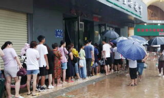 Heavy floods in Central China Zhengzhou epa09356103 People queue on a flooded road amid heavy rain in Zhengzhou, Henan province, China, 21 July 2021. Heavy floods in Central China killed 12 in Zhengzhou city due to the rainfall yesterday, 20 July 2021, according to official Chinese media. Over 144,660 people have been affected by heavy rains in Henan Province since July 16, and over 10,000 had to be relocated, the provincial flood control and drought relief headquarters said Tuesday. EPA/Costfoto CHINA OUT