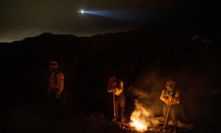 Palisades Fire prompts evacuations in Topanga, California epa09203507 Firefighters stay warm by a small fire as they keep an eye on the Palisades Fire in Topanga, California, USA, 15 May 2021. The fire had burned over 700 acres by nightfall, prompting evacuations. EPA/CHRISTIAN MONTERROSA